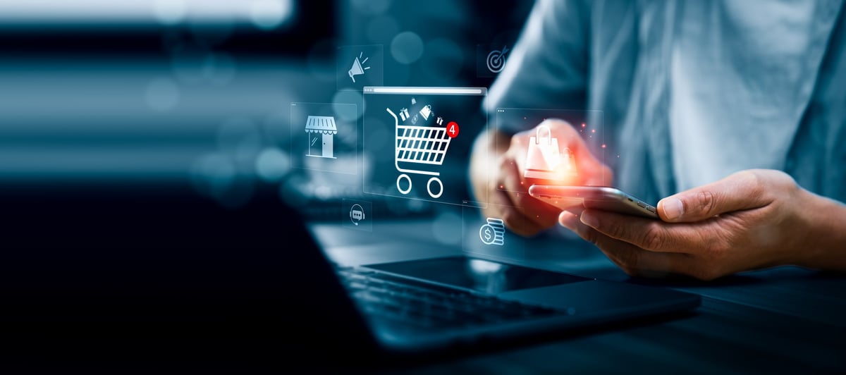 Business professional using a smartphone showing an online shopping cart interface with digital commerce icons, representing ecommerce transactions and mobile shopping